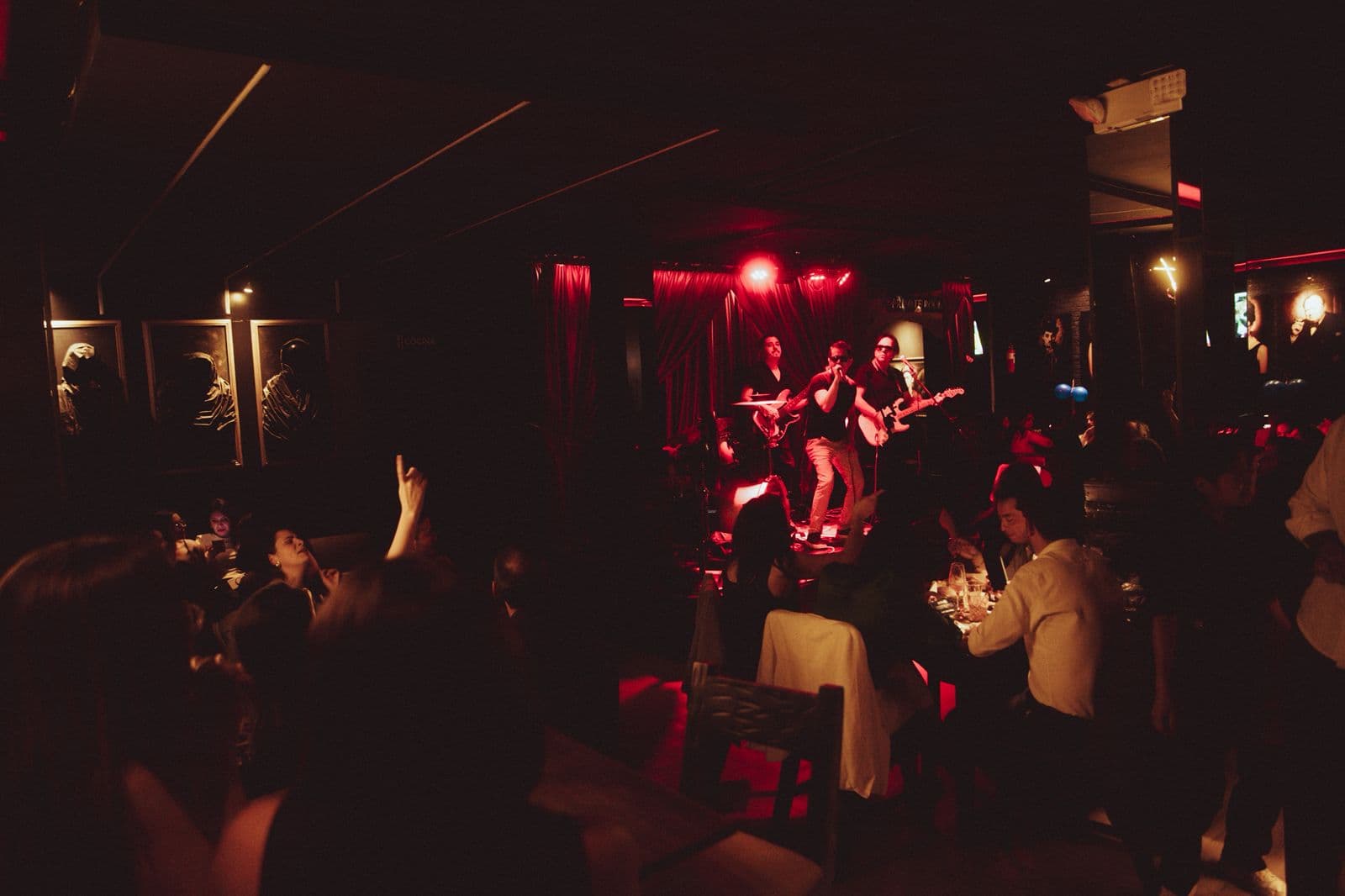 Banda en vivo bajo luz roja en Velvet
