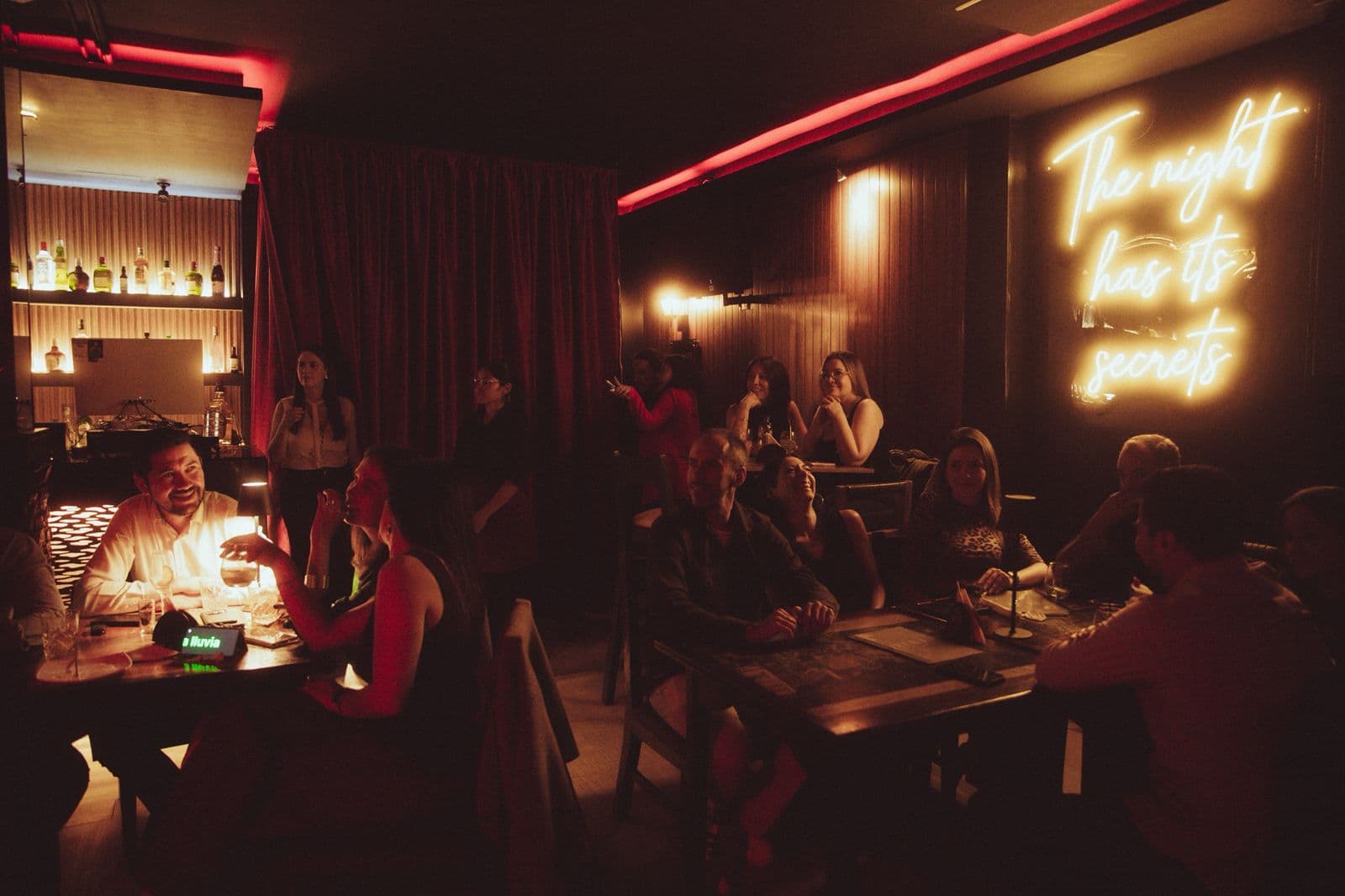 Salón Velvet con letrero luminoso: The night has its secrets